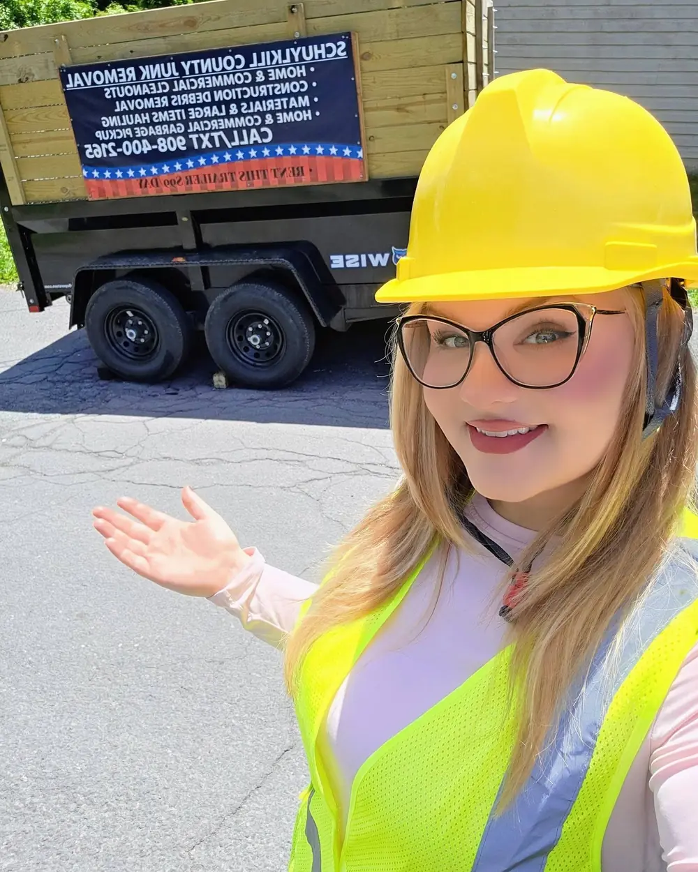 One of the owners in a hard hat and hi-vis vest beside the trailer