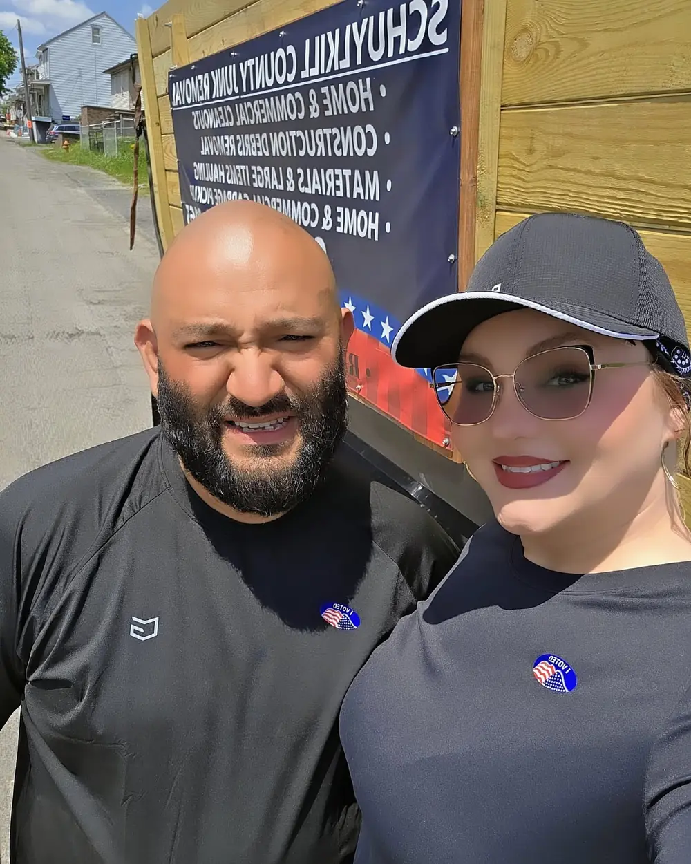 The husband-and-wife owners of Schuylkill County Junk Removal standing beside their dump trailer