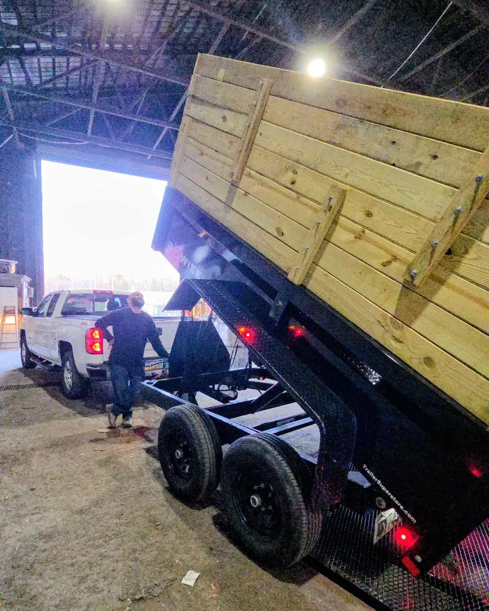 The dump trailer backed into a covered transfer station bay